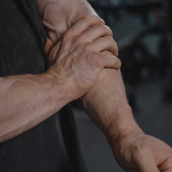 Man demonstrating a controlled strength exercise in a modern, dark gym setting.