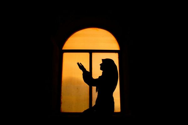 Silhouette of a person meditating at sunrise, representing mind-body connection.